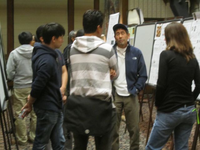 Dr. Harada discusses the posters with attendees from various labs